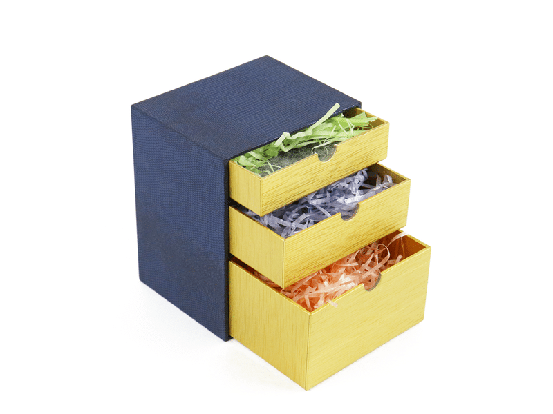 Custom navy blue and gold three-drawer rigid gift box with shredded paper filler, designed for luxury cosmetics, jewelry, accessories and premium gift packaging.