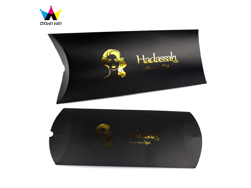 Custom black pillow-shaped paper box with gold foil logo printing, designed for hair extensions, wigs, beauty products and luxury cosmetic packaging.