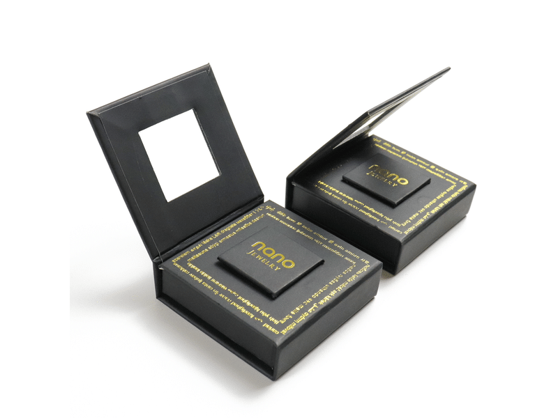 Custom black hinged rigid jewelry presentation boxes with gold foil printing, raised display inserts and a transparent window lid for rings and premium accessories.