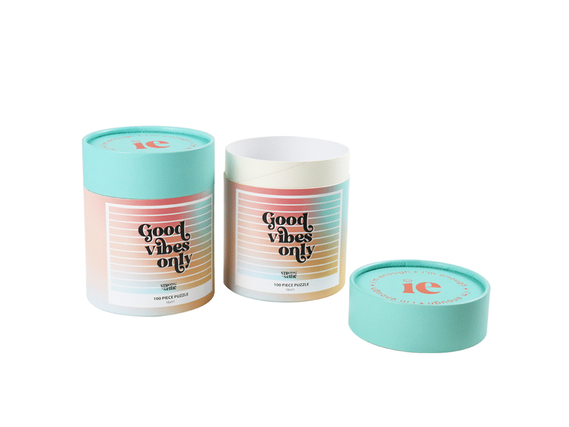 Custom pastel-colored cylindrical paper tube packaging with removable lid and printed branding, designed for puzzles, gifts, cosmetics and premium retail products.