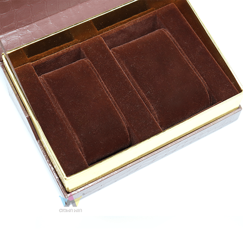Close-up of a premium rigid watch packaging box featuring brown crocodile skin texture paper, a shiny gold interior extension rim, and a plush chocolate brown velvet dual watch slot insert.
