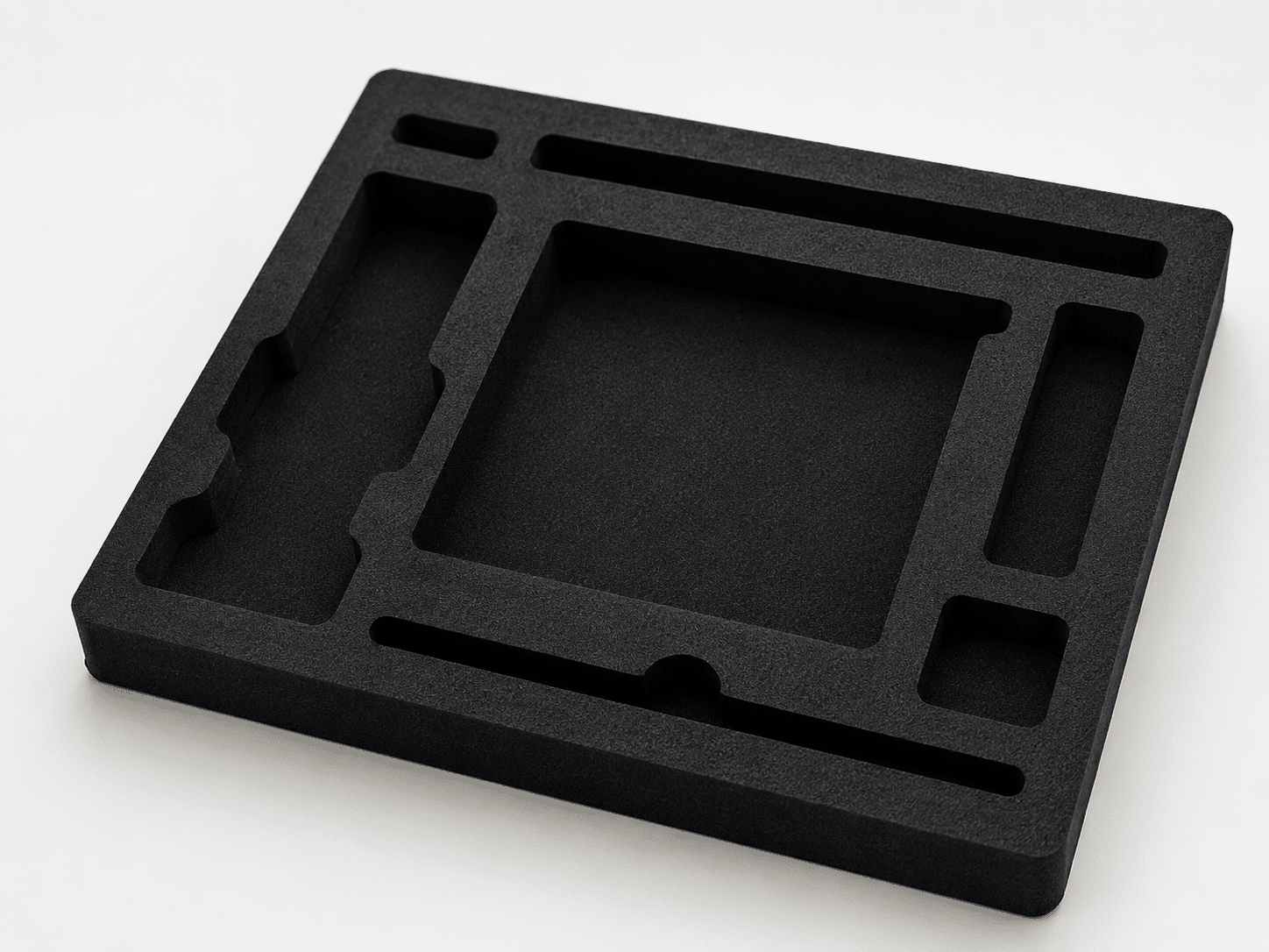 Custom black EVA foam packaging insert with precision-cut compartments for securing multiple products inside corrugated mailer boxes