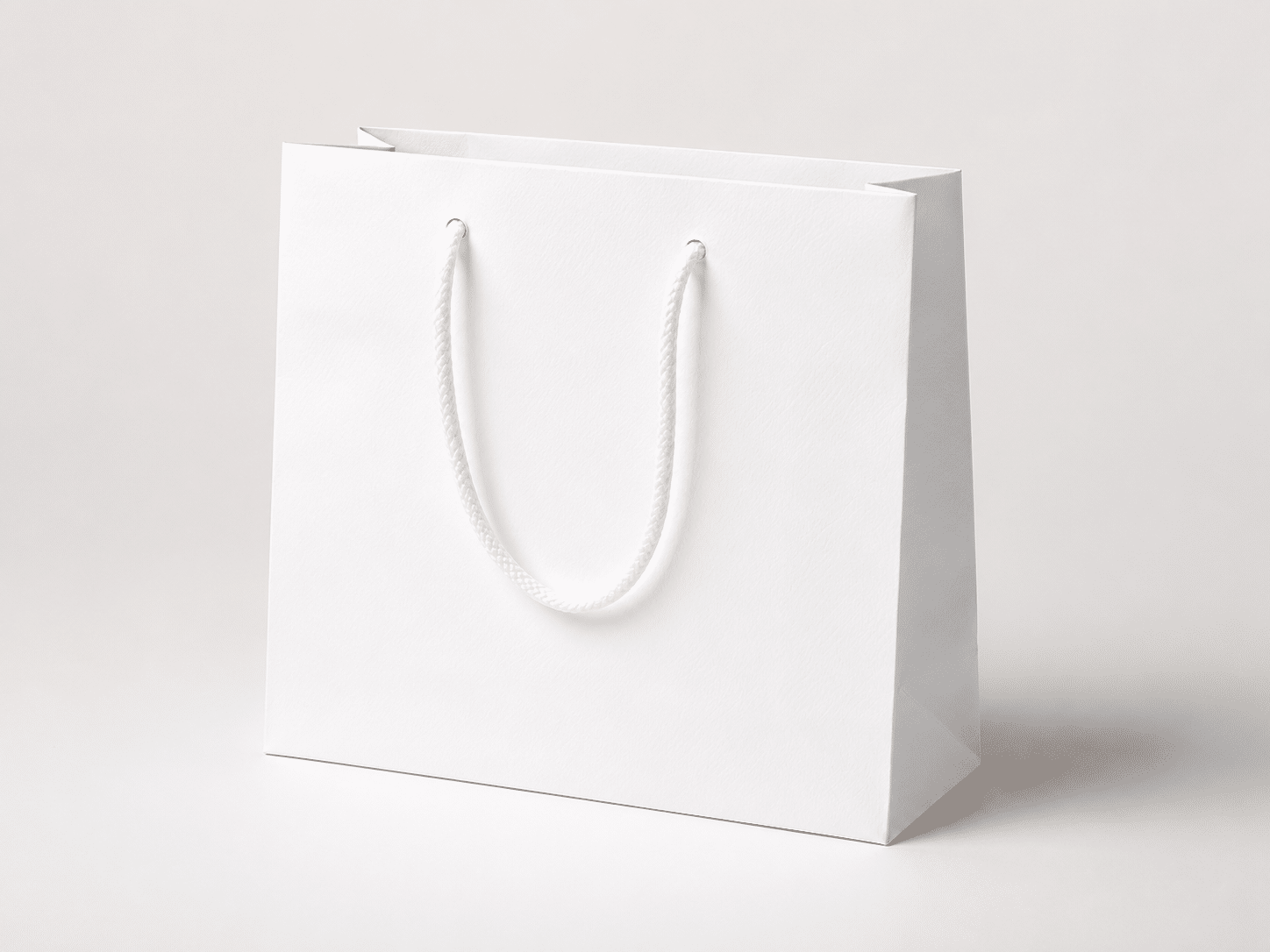 Plain white paper shopping bag with matching braided rope handles for retail, gift, cosmetic and promotional packaging