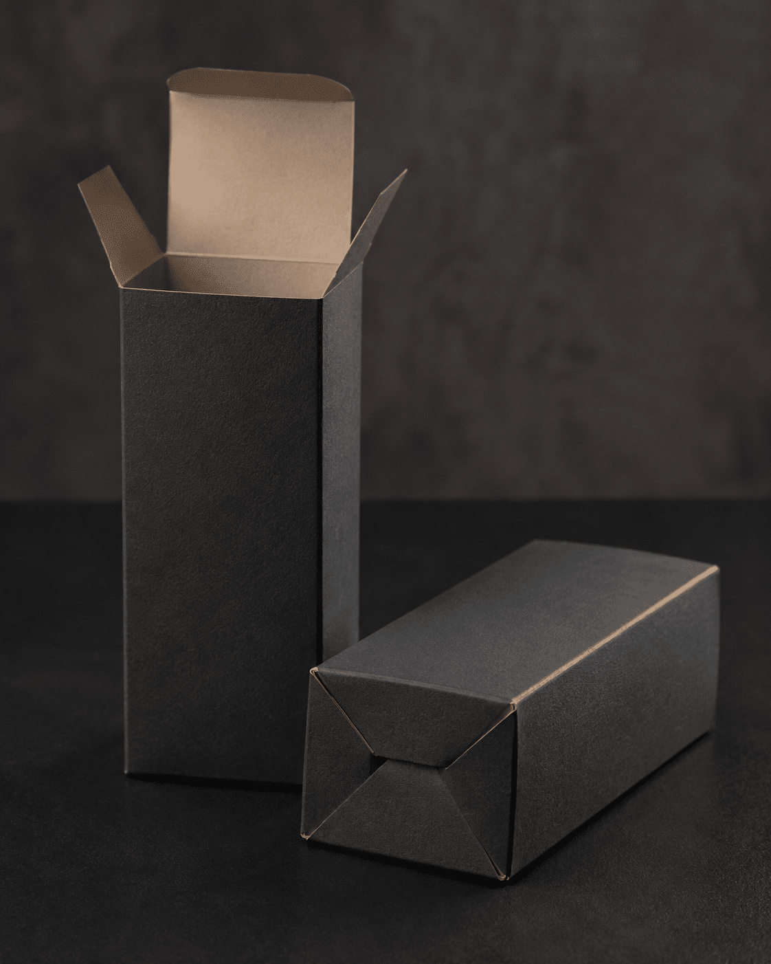Black folding carton showing an open top and secure auto-lock bottom packaging structure