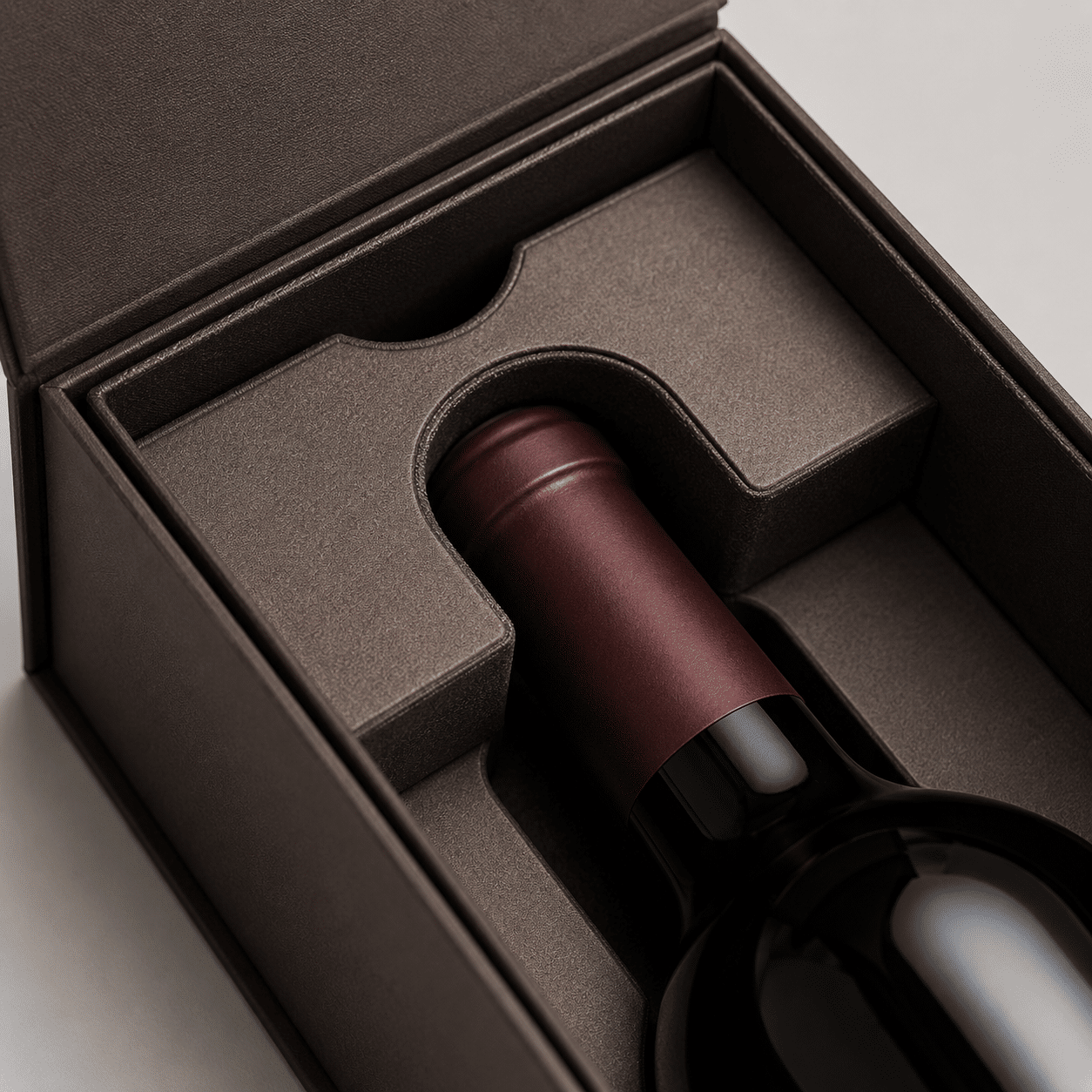Close-up of a fitted protective insert securely holding the neck and body of a wine bottle inside a rigid gift box