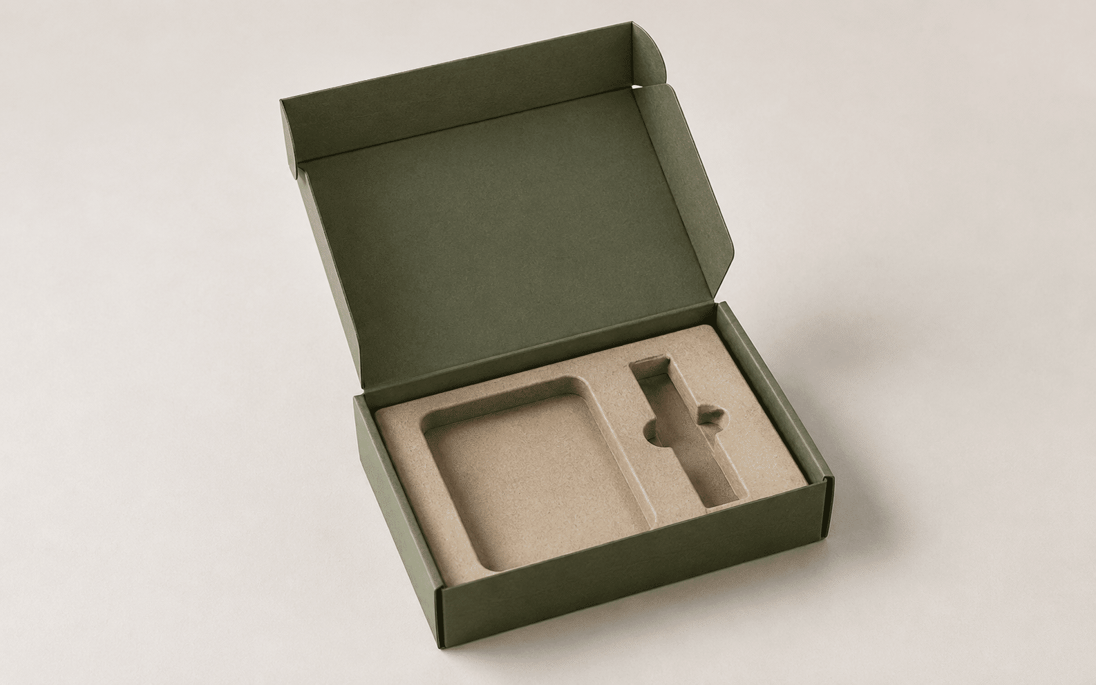 Open green folding carton fitted with a custom molded pulp insert for sustainable and protective product packaging.