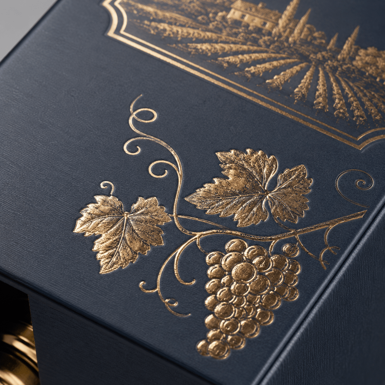 Close-up of a navy luxury wine box featuring gold foil grape artwork, embossed details and premium textured paper
