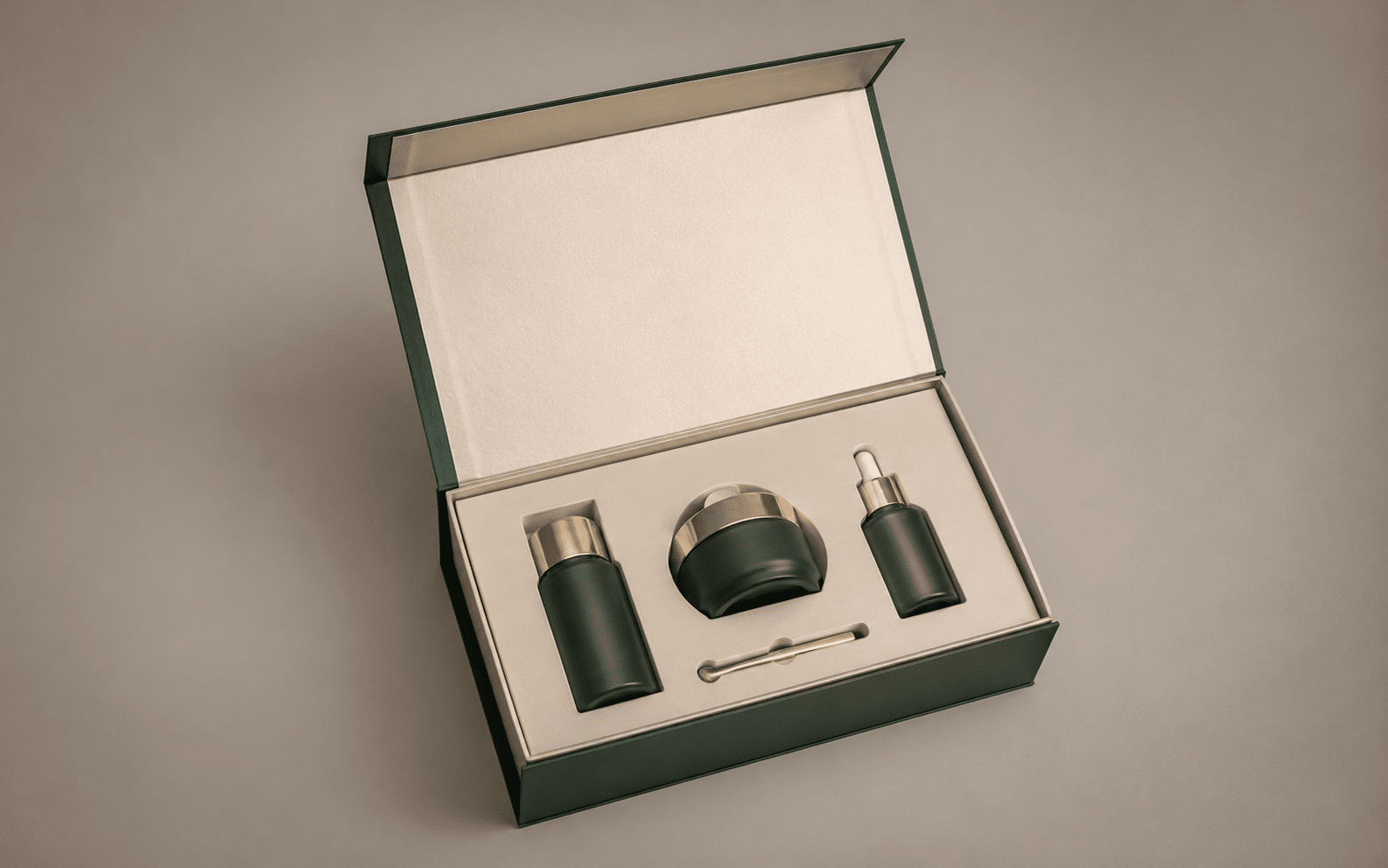 Open green magnetic closure gift box with a cream custom insert holding skincare bottles, a cosmetic jar and applicator.