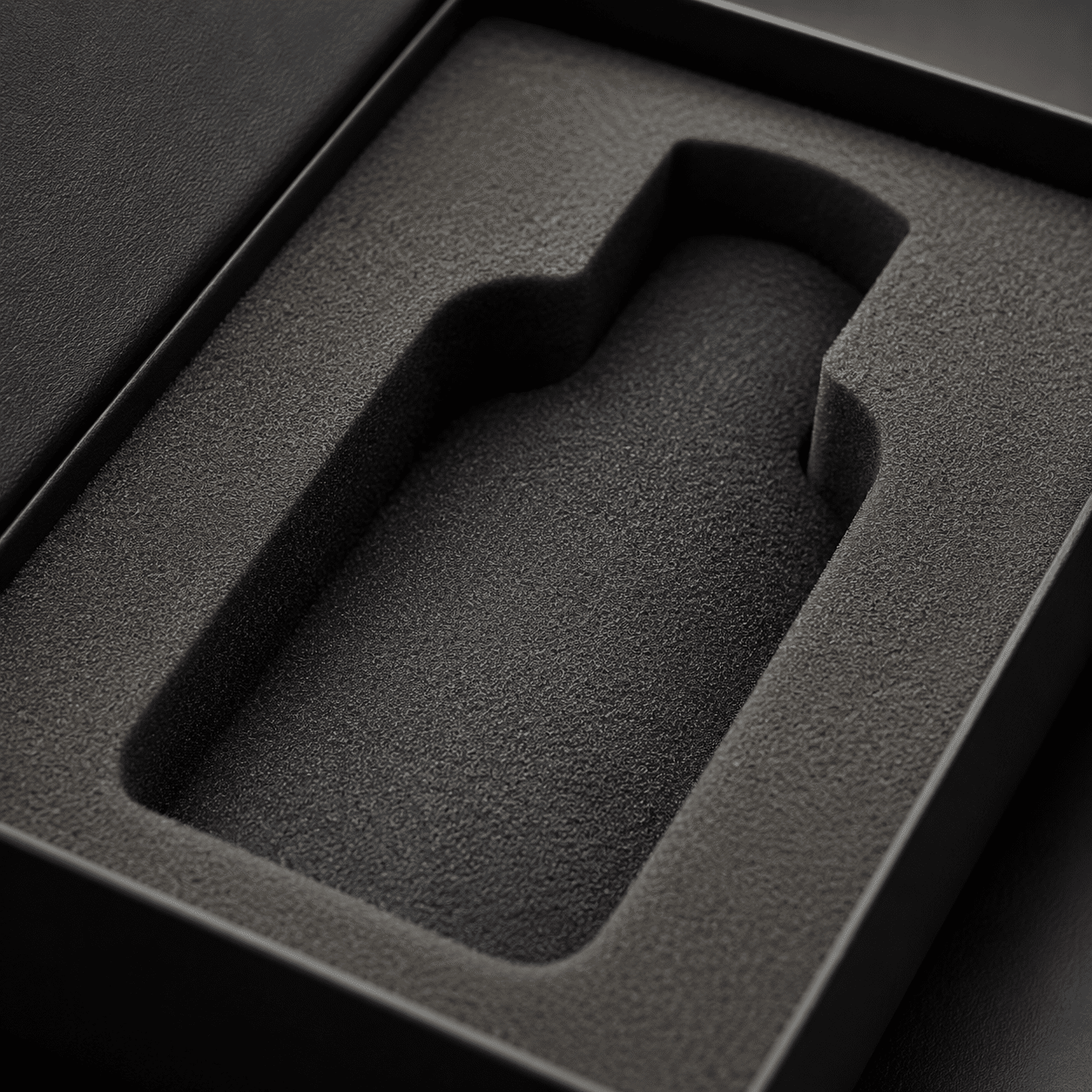 Close-up of a black precision-cut EVA foam packaging insert with a custom-shaped cavity for secure product placement.