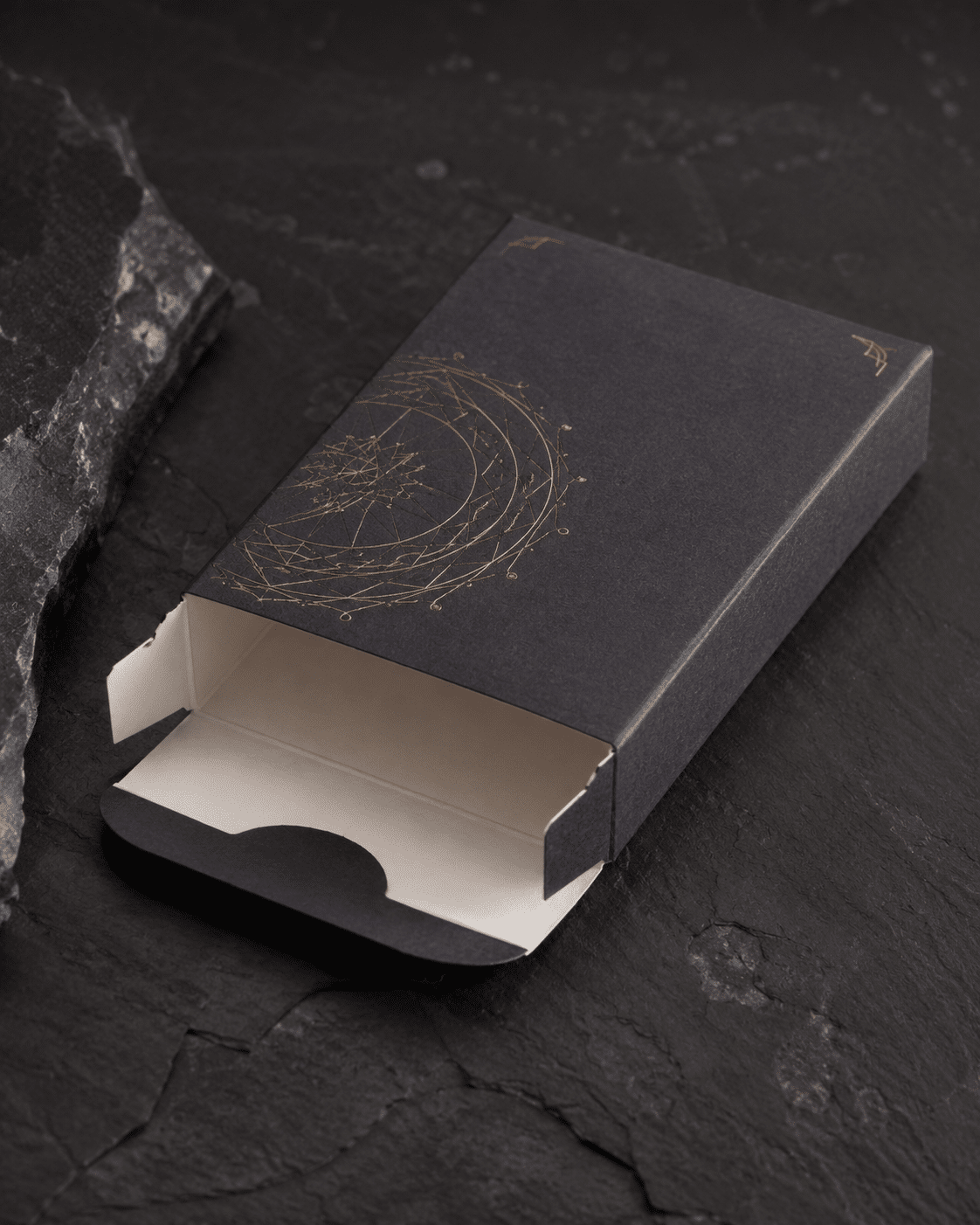 Custom black reverse tuck end folding carton with gold printed pattern and open closure flaps